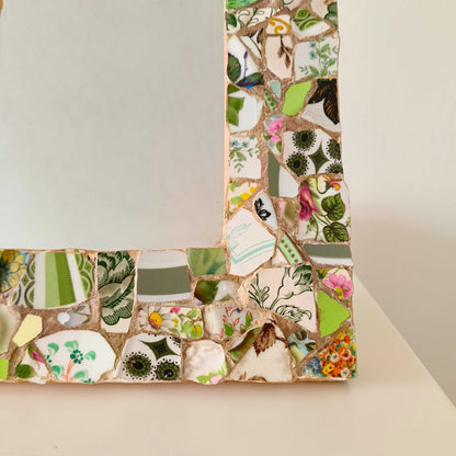 Vintage mosaic picture frame with ceramic and tile fragments in soft greens and botanical motifs
