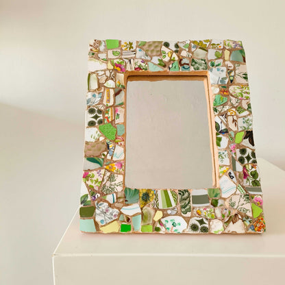Vintage mosaic picture frame with ceramic and tile fragments in soft greens and botanical motifs