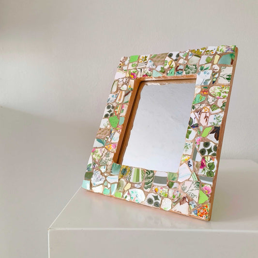 Vintage mosaic picture frame with ceramic and tile fragments in soft greens and botanical motifs