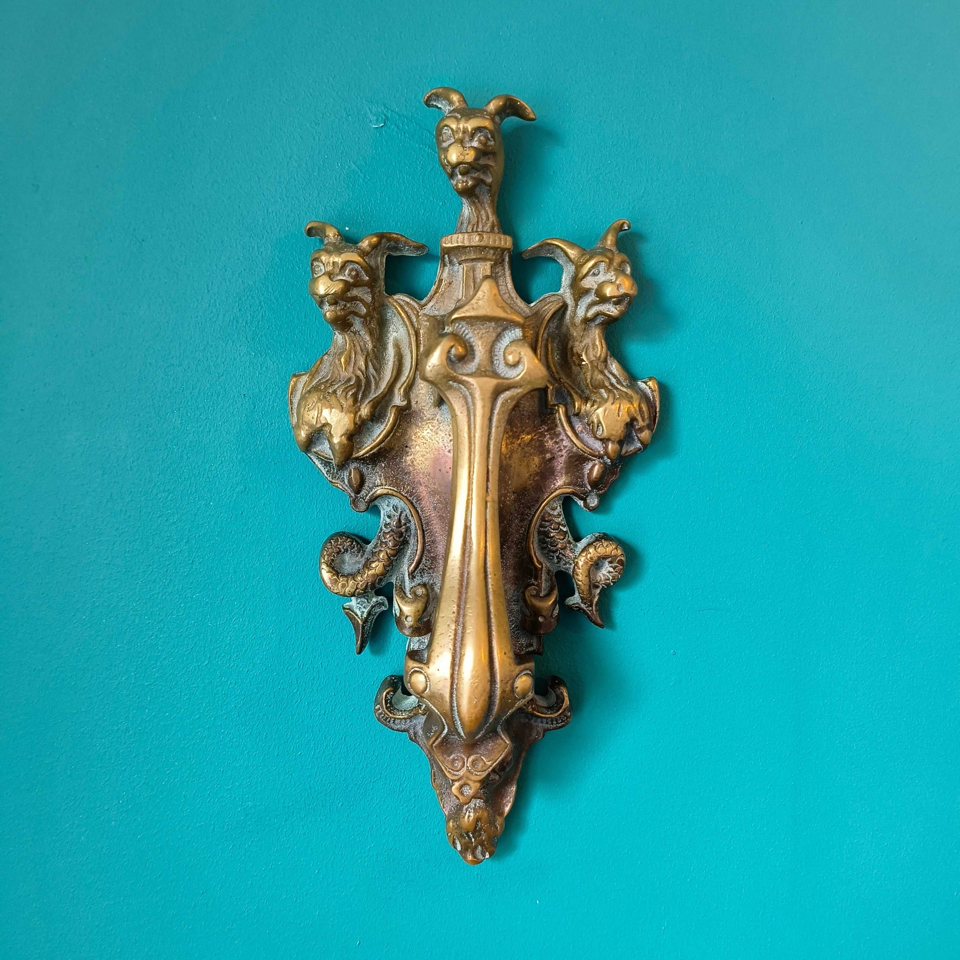 Early Victorian brass door knocker featuring three-headed Cerberus design in solid brass