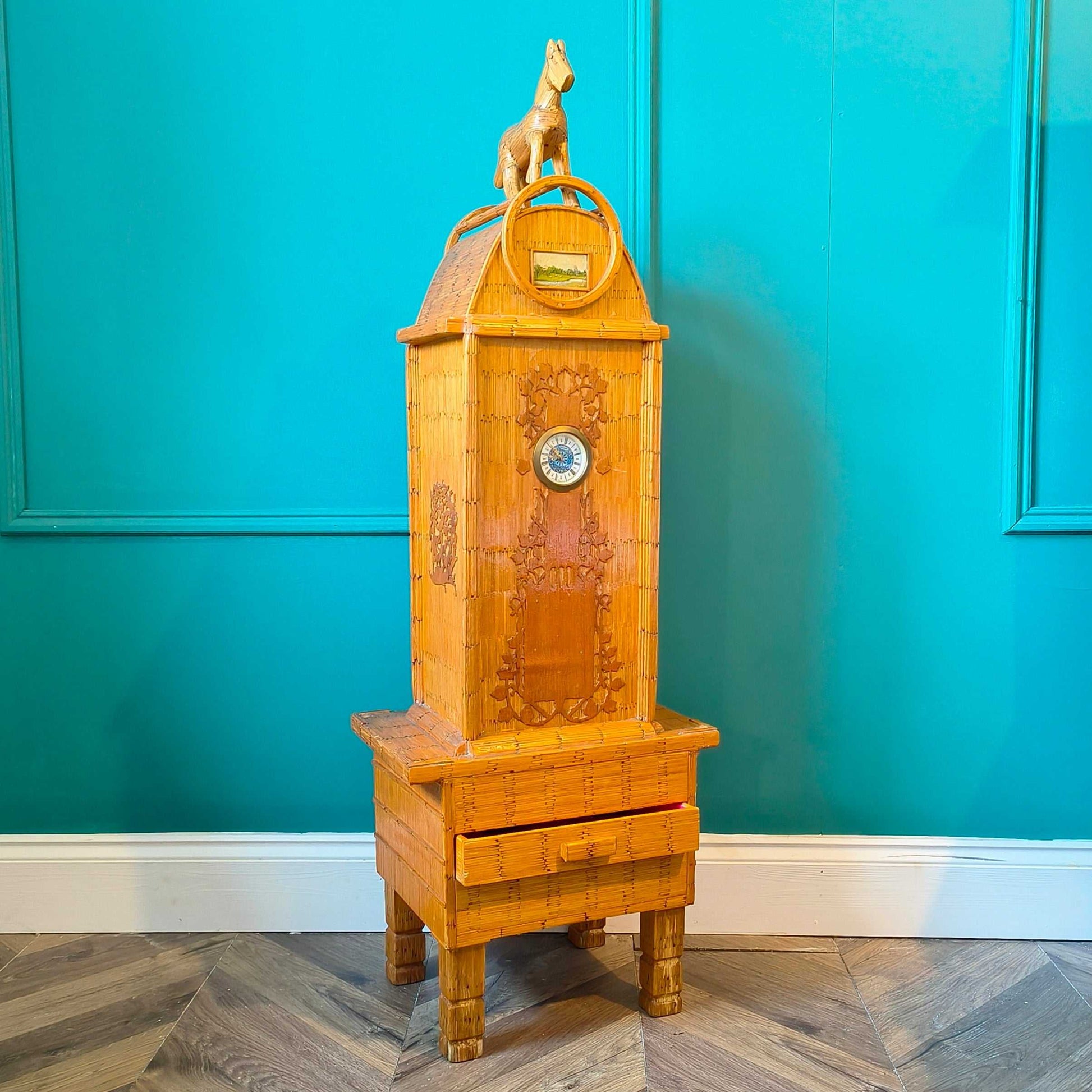 Likely German Mid-century. Constructed from matchsticks with a working clock and a drawer at the base.
Features a decorative horse figure on the very top.
Intricate jail-style folk Art.