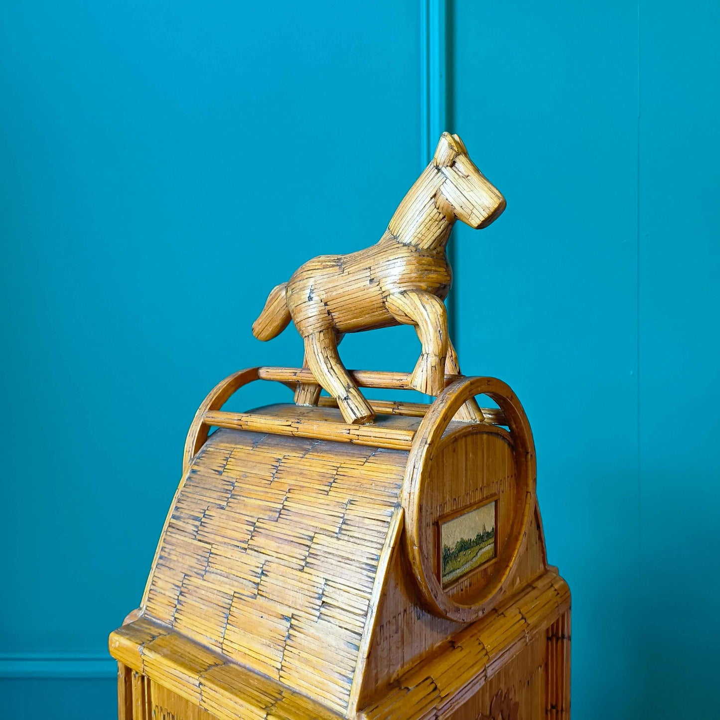 Likely German Mid-century. Constructed from matchsticks with a working clock and a drawer at the base.
Features a decorative horse figure on the very top.
Intricate jail-style folk Art.